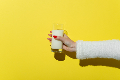 Cropped Hand Holding Milk Glass