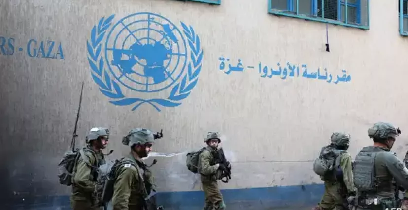 جنود إسرائيليون أمام مقر الأونروا في غزة (رويترز)